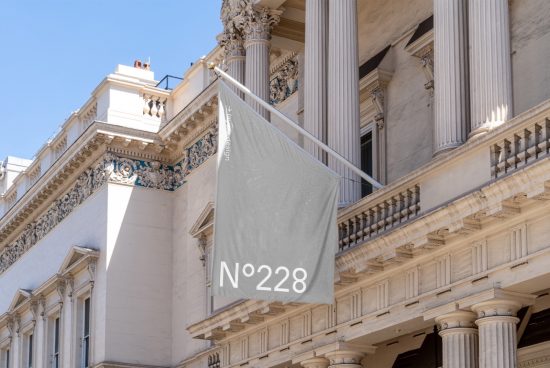 Mockup of a neutral hanging banner on a classical building exterior with columns and ornate details, perfect for showcasing design work.