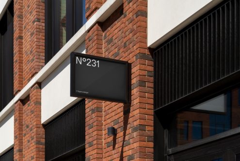 Modern building signage mockup on red brick wall exterior for brand identity and logo presentation, suitable for design templates.