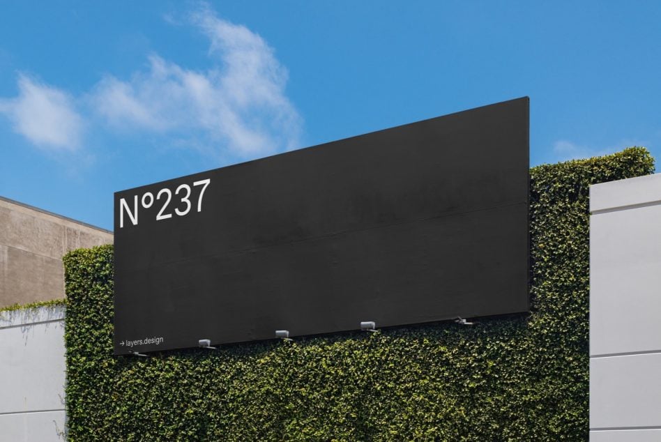 Dark horizontal sign N°237 mounted above dense green foliage screening