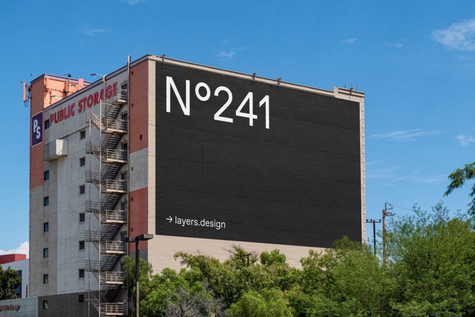 Urban billboard mockup on building exterior with clear sky for graphic designers, advertising mockup, editable outdoor advertising template.