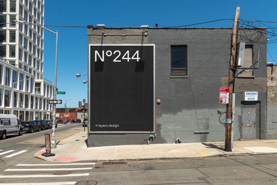 Black billboard on gray building corner with white text displaying N°244