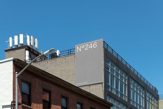 Urban billboard mockup on building exterior for advertising display, clear blue sky, designers' digital assets marketplace.