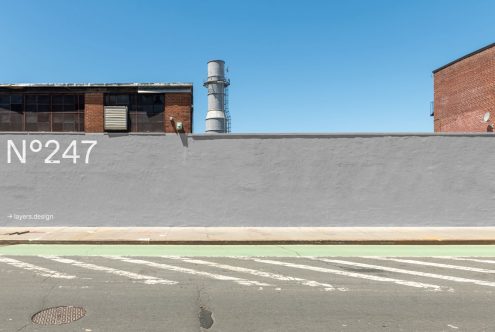 Urban industrial wall with number 247, clear sky, mockup textures for design assets, realistic street scene for graphic backgrounds.