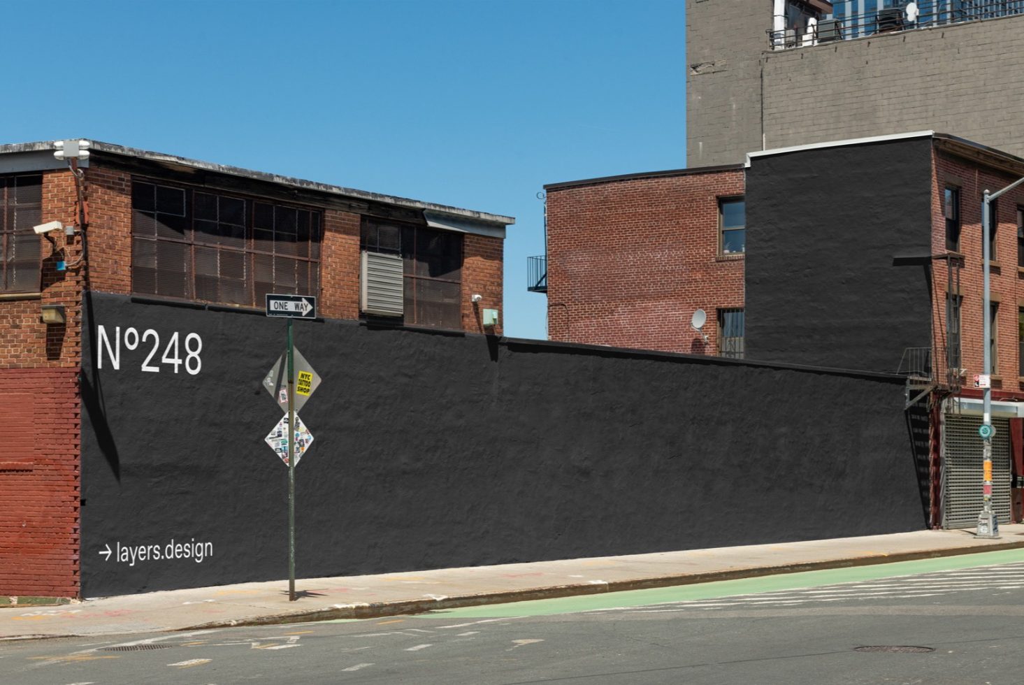 Urban building wall with a large black space for advertising, ideal for mockup designs, with clear blue sky.