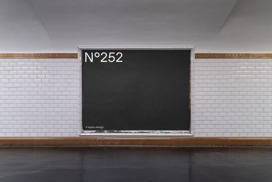 Black storefront window display on light brick with bronze trim