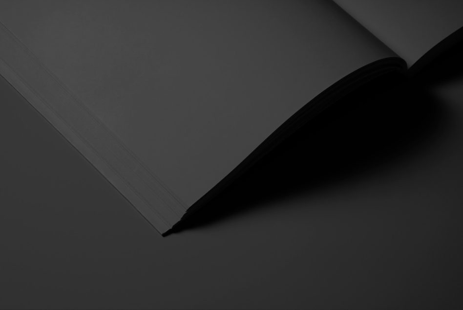 Book pages curved open showing binding on dark base