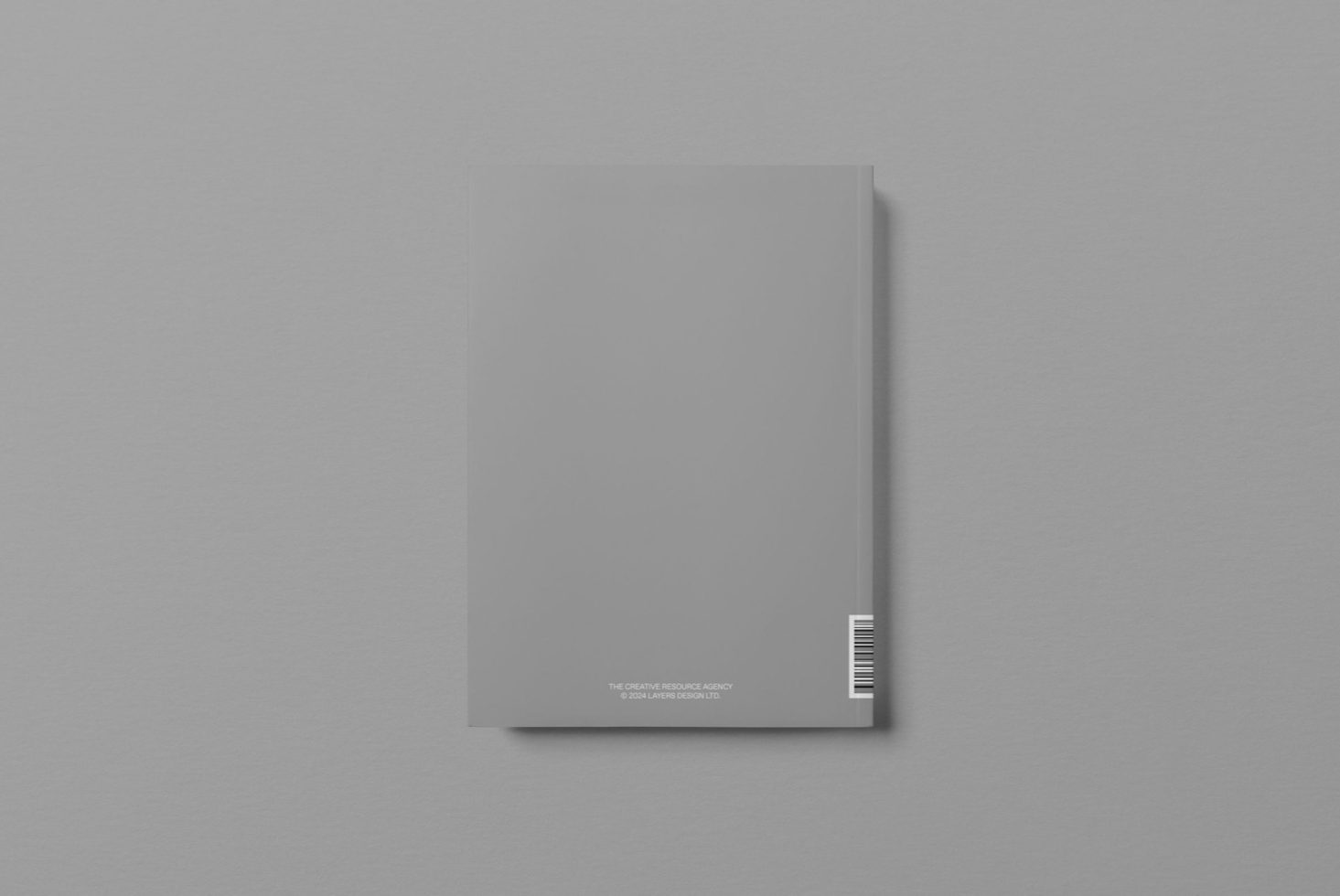 Minimalist magazine mockup with blank cover and barcode on grey background, perfect for editorial design presentations.