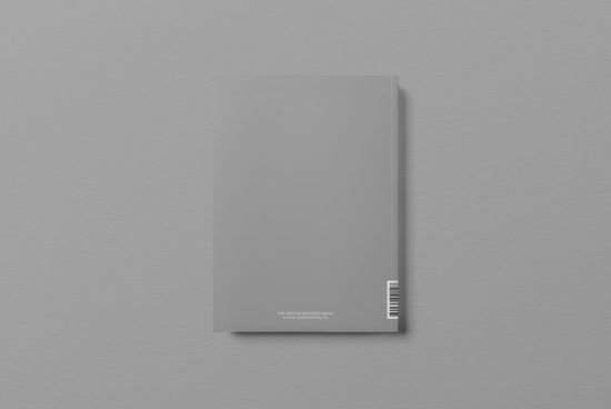 Minimalist magazine mockup with blank cover and barcode on grey background, perfect for editorial design presentations.