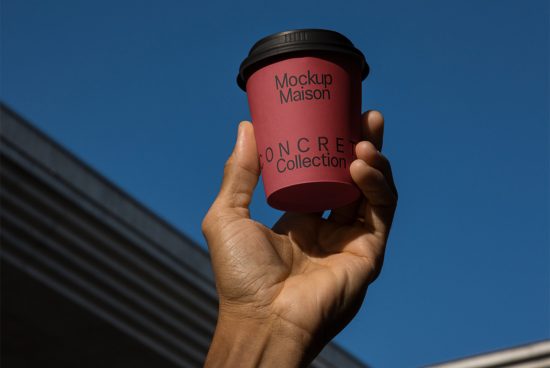 Hand holding a custom branded coffee cup mockup against a clear blue sky, ideal for showcasing coffee shop logo designs.