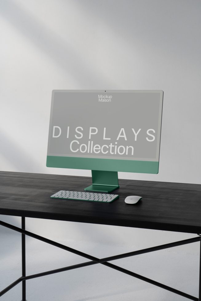 Modern computer display mockup on a dark desk against a light wall, with keyboard and mouse, ideal for digital design presentations.