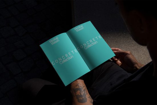 Man holding open magazine mockup with teal cover, realistic shadows, urban design presentation, brochure mockup for graphic designers.