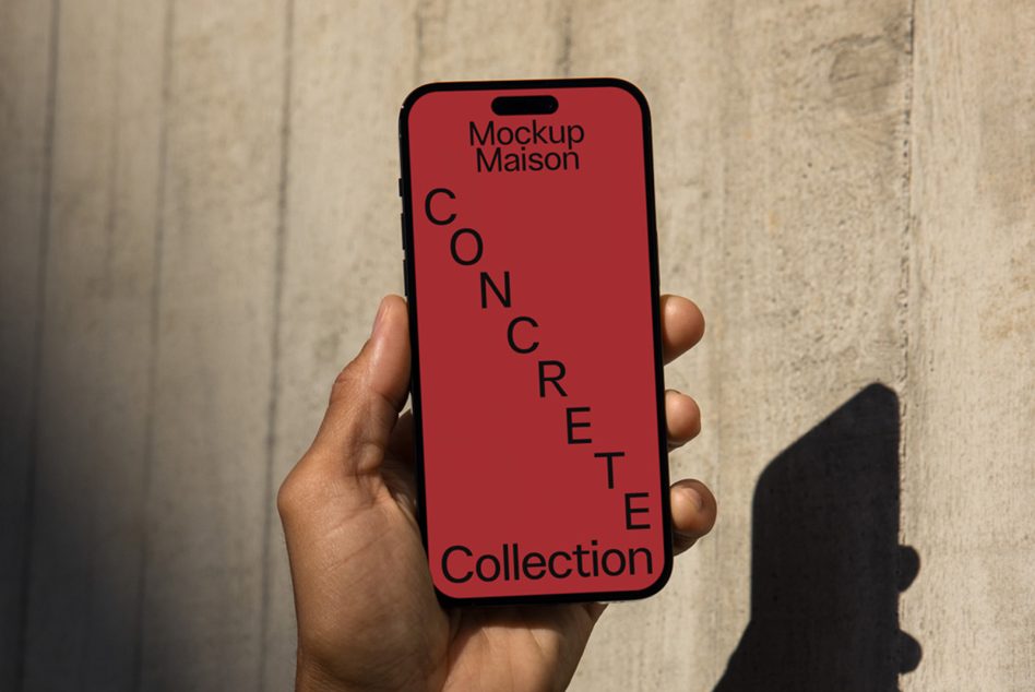 Hand holding smartphone mockup with red screen and concrete wall background for urban design presentations.