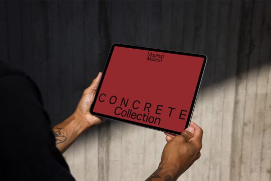 Person holding tablet mockup with red screen reading Concrete Collection against dark wood background for designers digital assets.