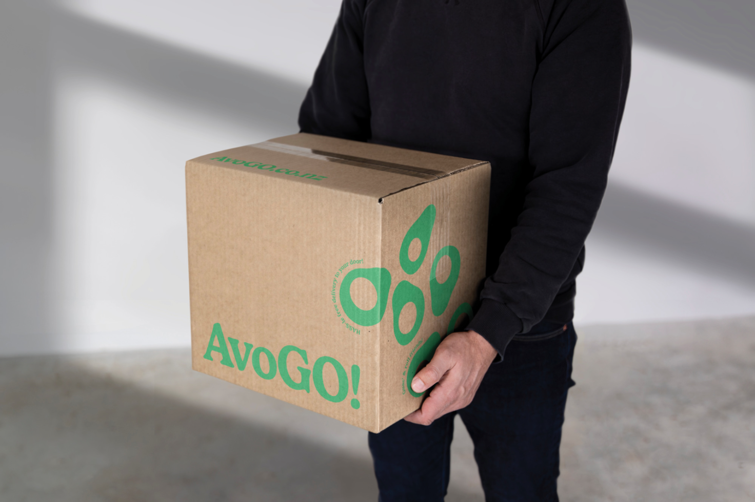 Person holding a cardboard box with logo design mockup, clear branding packaging, editable template graphic for designers.