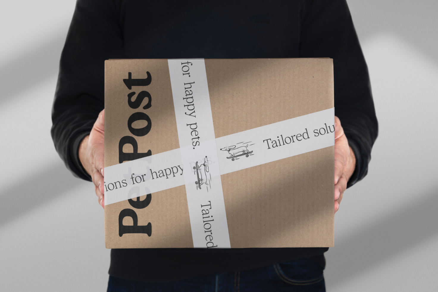 Person holding a branded cardboard box with design mockup, ideal for packaging and branding projects, in a realistic setting for designers.