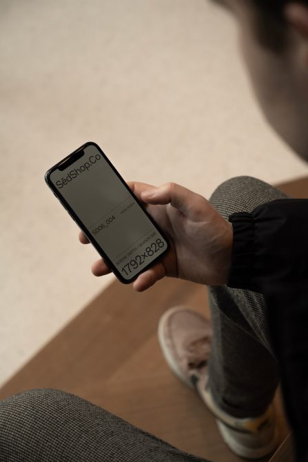 Man holding smartphone with design mockup screen, suited for app presentations and digital assets, clear and modern display, perspective view.