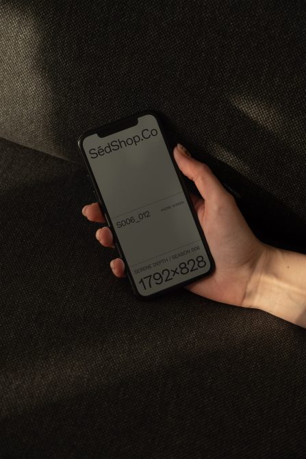iPhone mockup displaying SedShop.Co branding on dark woven background