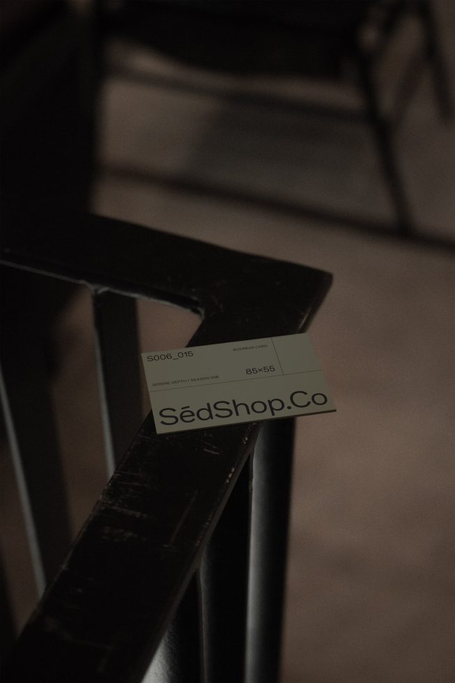 Elegant business card mockup on dark metal chair for branding, graphic design, showcasing corporate identity in a sophisticated setting.