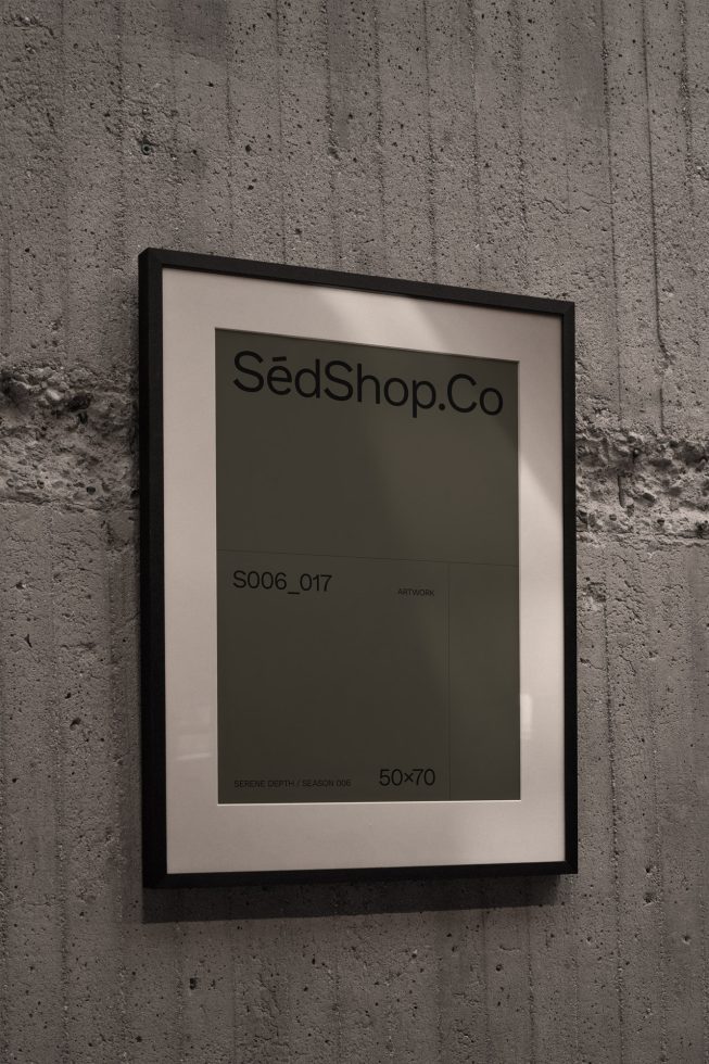 Wall-mounted poster mockup in a sleek black frame against a textured concrete wall, ideal for presentations and portfolio displays for designers.