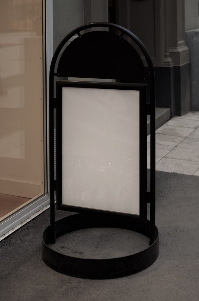 Empty sidewalk poster mockup with black frame for design presentations, standing outdoor advertising display mockup.