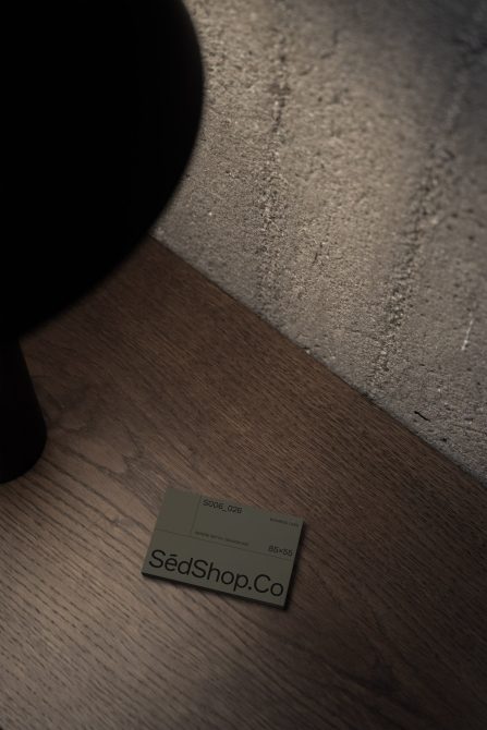 Business card mockup on wooden floor with dramatic lighting ideal for presentations, branding, graphic design.