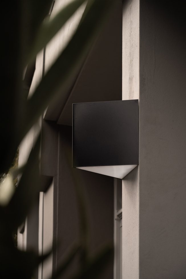 Modern exterior wall-mounted light fixture design, ideal for mockup displays, showcasing architectural lighting with shadow play for design projects.