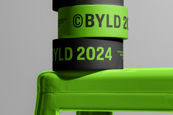 Close-up view of green branded tape Rolls with BYLD 2024 text on a green chair, ideal for mockup graphic design presentation.