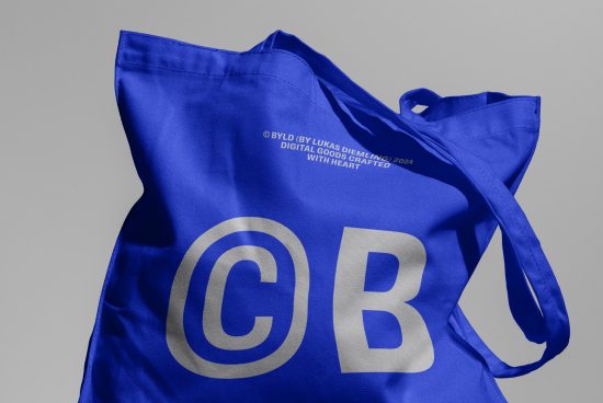 Blue tote bag mockup with white text design, realistic fabric texture, for digital assets in branding and packaging designs.