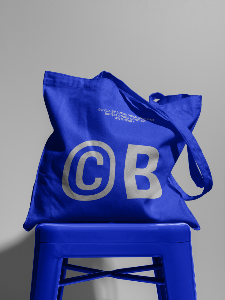 Blue tote bag mockup on blue chair, bold graphic lettering, designer marketplace asset, high-resolution, versatile, realistic shadow.