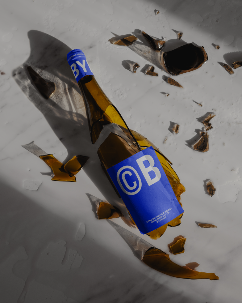 Broken beer bottle with label and shards on white surface, realistic product mockup for branding and packaging design.