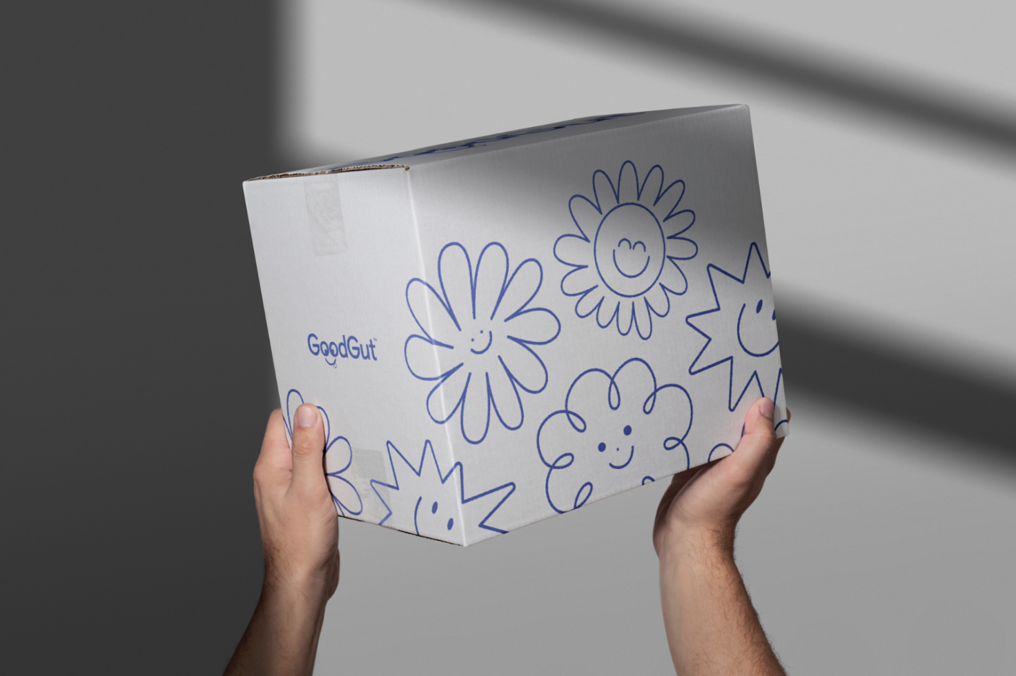 Hands holding a flower-patterned box with shadow play, perfect for mockup presentations, packaging design showcase, and print graphics.