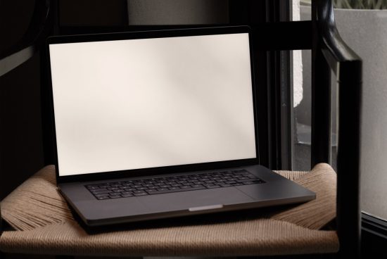Laptop mockup on chair with blank screen for graphic display, digital asset for designer workspace presentation, elegant design.