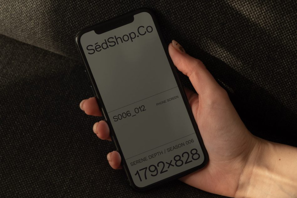Phone mockup in hand showing SédShop.Co branding with blank screen space