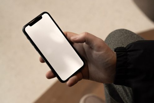 Person holding smartphone with blank screen, ideal for mockup design, template display, and UI/UX presentation for digital assets.