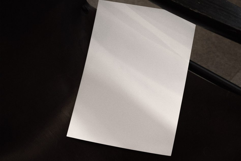 Blank A4 paper mockup on a dark surface for presentation of designs, stationery templates, and text layouts with a realistic shadow effect.