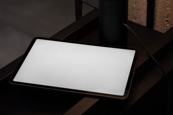 Digital tablet mockup on dark desk, modern stylized office setting, suitable for presenting UI/UX designs and templates.