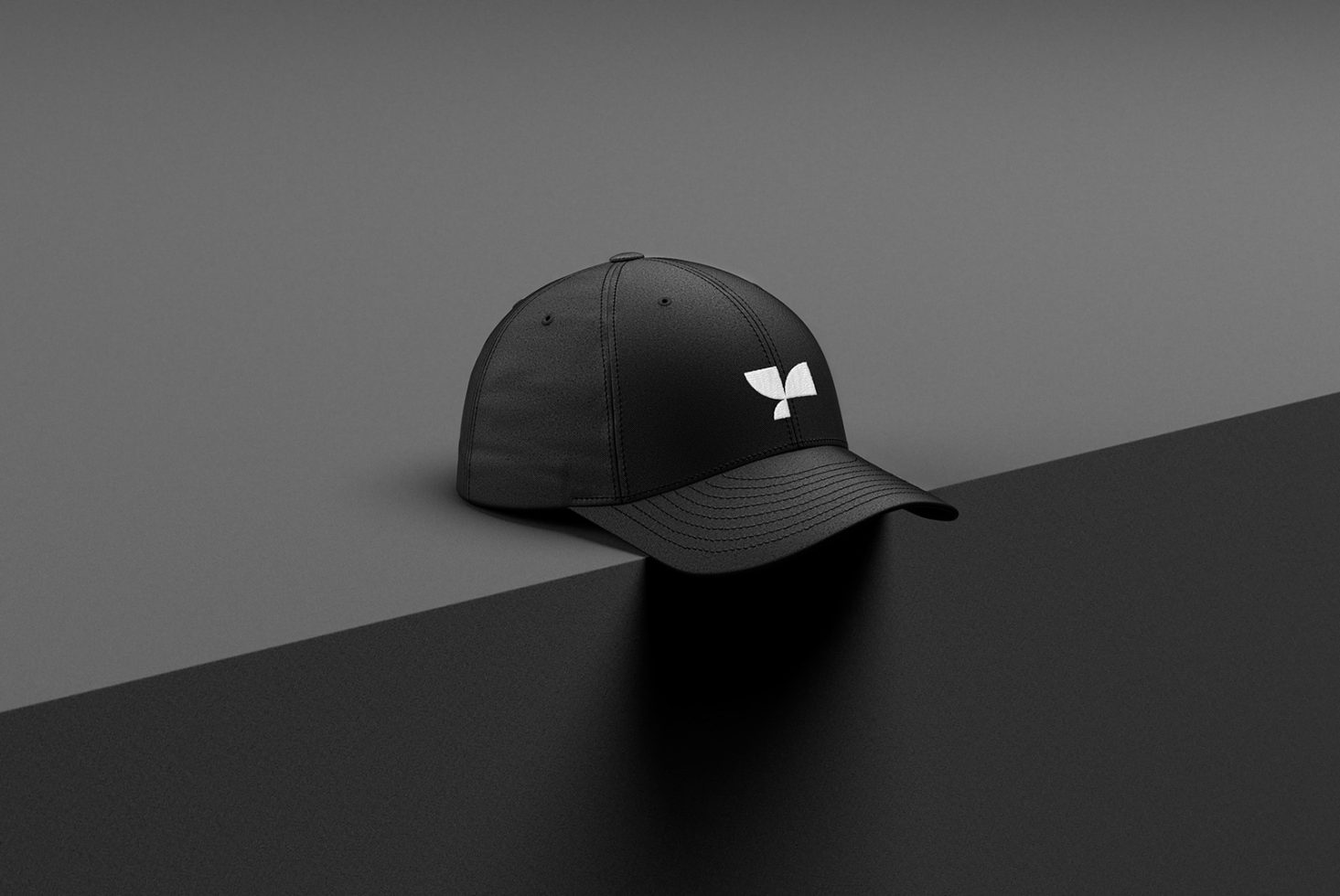 Black cap with white logo mockup on a dual-tone background, ideal for branding presentations and design assets.