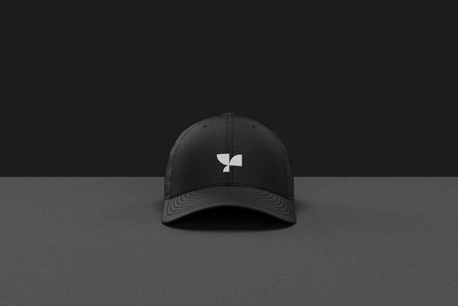 Black baseball cap mockup with minimalist logo on a dark background, ideal for presenting apparel designs and branding for fashion designers.