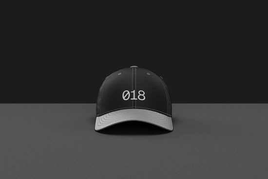 Black baseball cap mockup with white stitching and number 018 design on dark background, ideal for apparel presentation.