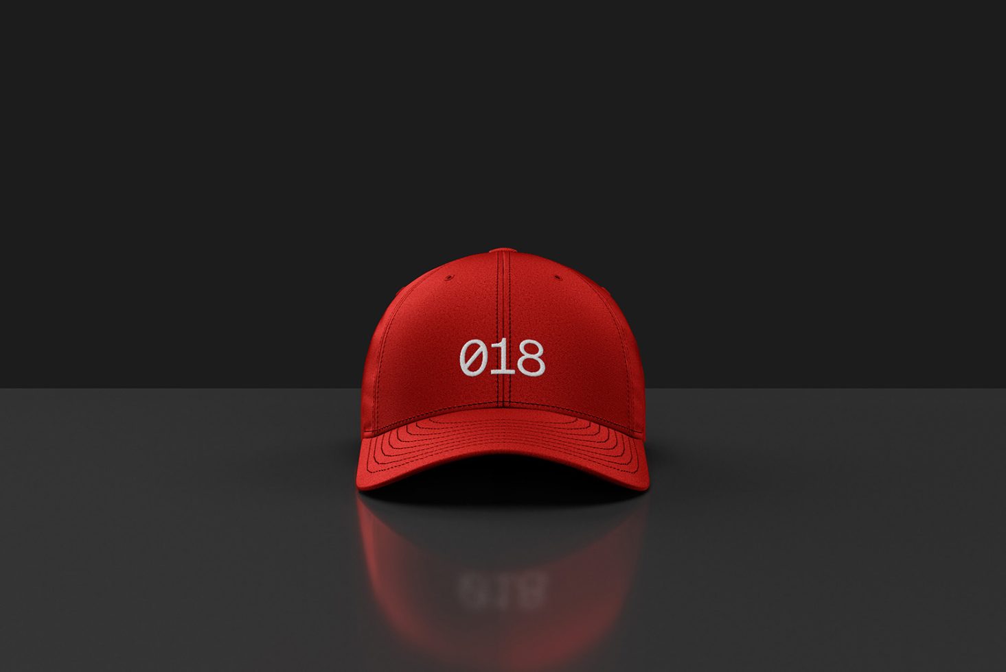 Red baseball cap mockup with white embroidery on front, highly detailed stitching, realistic shadows and glossy reflection on dark background.