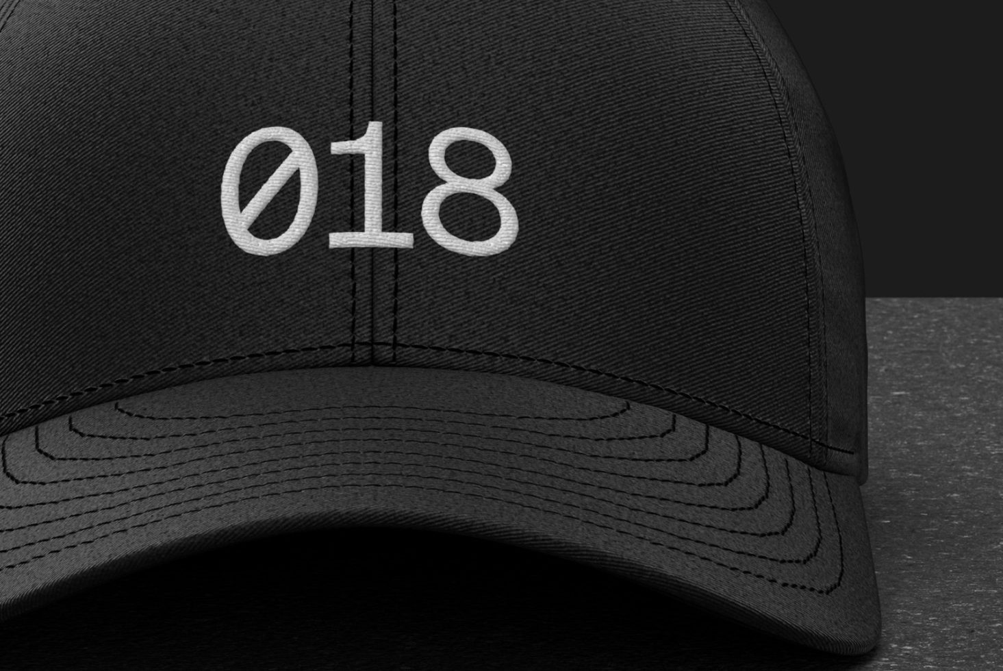 Close-up of a black baseball cap mockup with embroidered design 018 showcasing texture and detail, ideal for brand presentations.