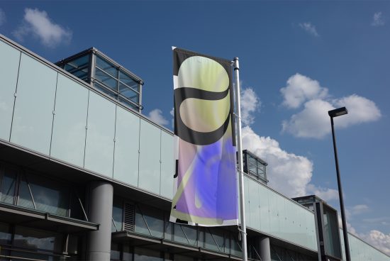 Outdoor flag mockup displayed on a modern glass building under a clear blue sky graphic design template for showcasing promotional banners SEO keywords