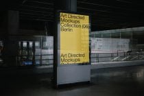 Yellow digital display panel in modern transit station with glass railings