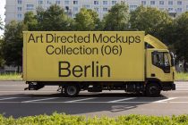 Bright yellow delivery truck with bold black typography on its cargo box