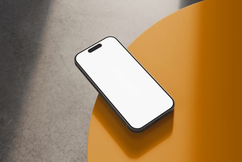 Smartphone mockup with blank screen on yellow surface and concrete background suitable for graphic designers digital assets templates branding SEO mockups.