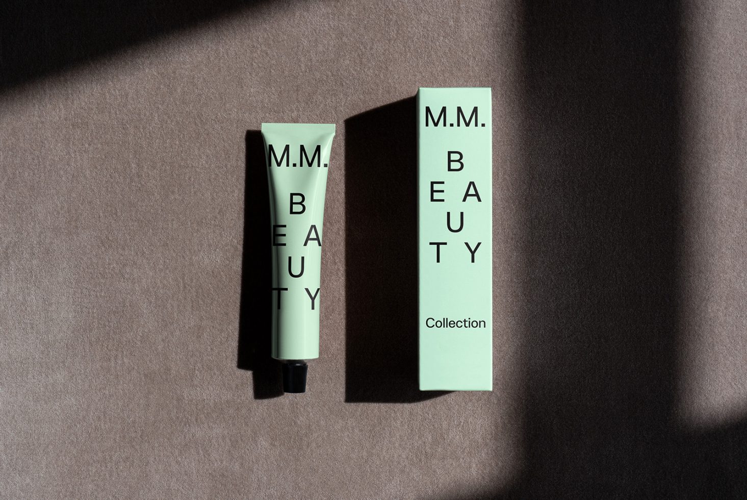 Beauty product packaging mockup featuring a green tube and box with modern typography. Perfect for designers seeking high-quality graphics for skincare branding.