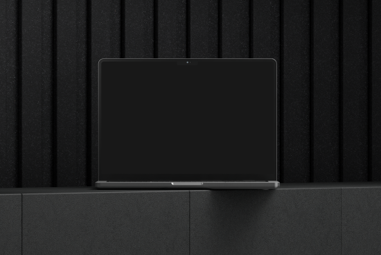 Laptop mockup with a black screen against a textured black background and surface suitable for showcasing digital designs templates and graphic projects.