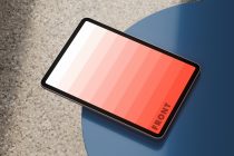 Tablet mockup with gradient color screen leaning on a blue surface suitable for digital design presentations and user interface displays. Suitable for designers.