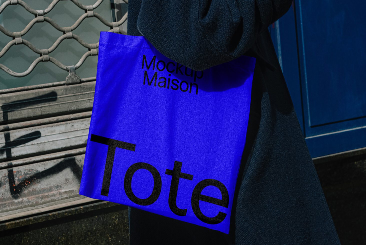 Blue tote bag mockup with bold black text Mockup Maison. Ideal for showcasing tote bag designs in graphics, mockups, templates. Creative design resource for designers