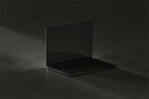 Modern open laptop mockup with blank black screen on dark concrete floor. Perfect for showcasing UI UX designs web templates and app interfaces. High-resolution graphic.